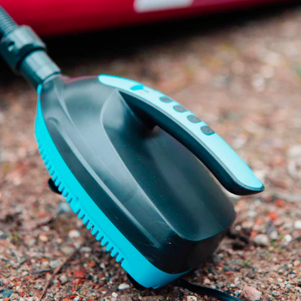 Black and teal electric pump with handle and buttons on a gravel surface