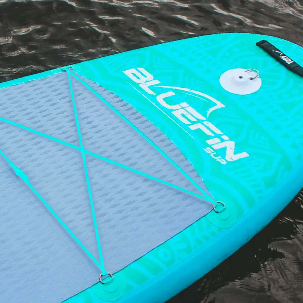 Paddleboard gonflable turquoise avec un pad de pont texturé et un système de rangement avec cordon élastique
