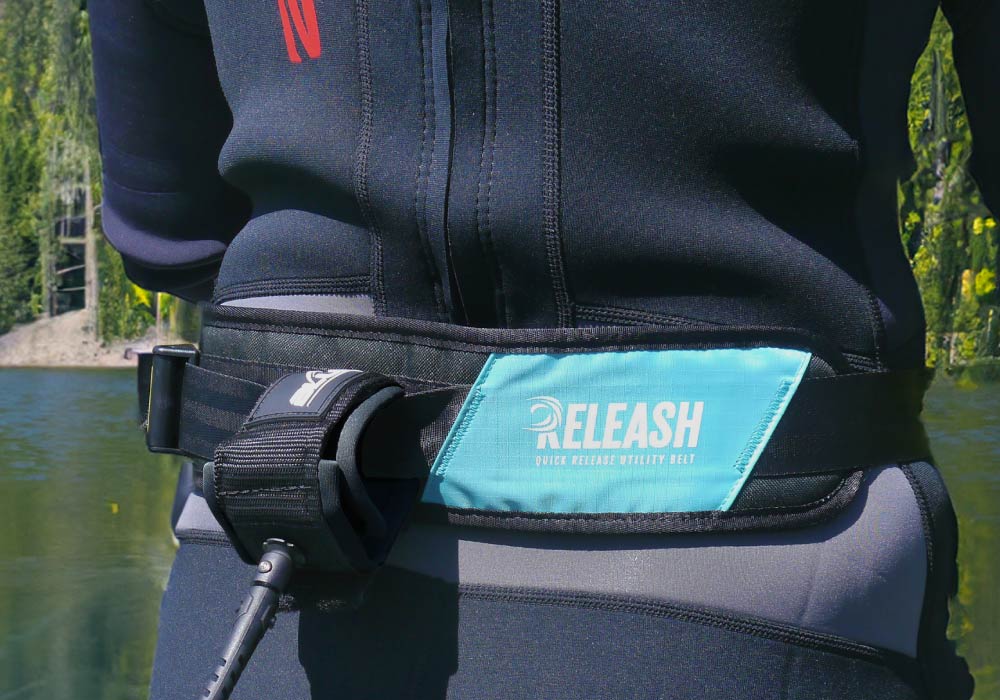 Quick release vitality belt worn over a wetsuit, featuring a blue panel with 'RELEASE' text.