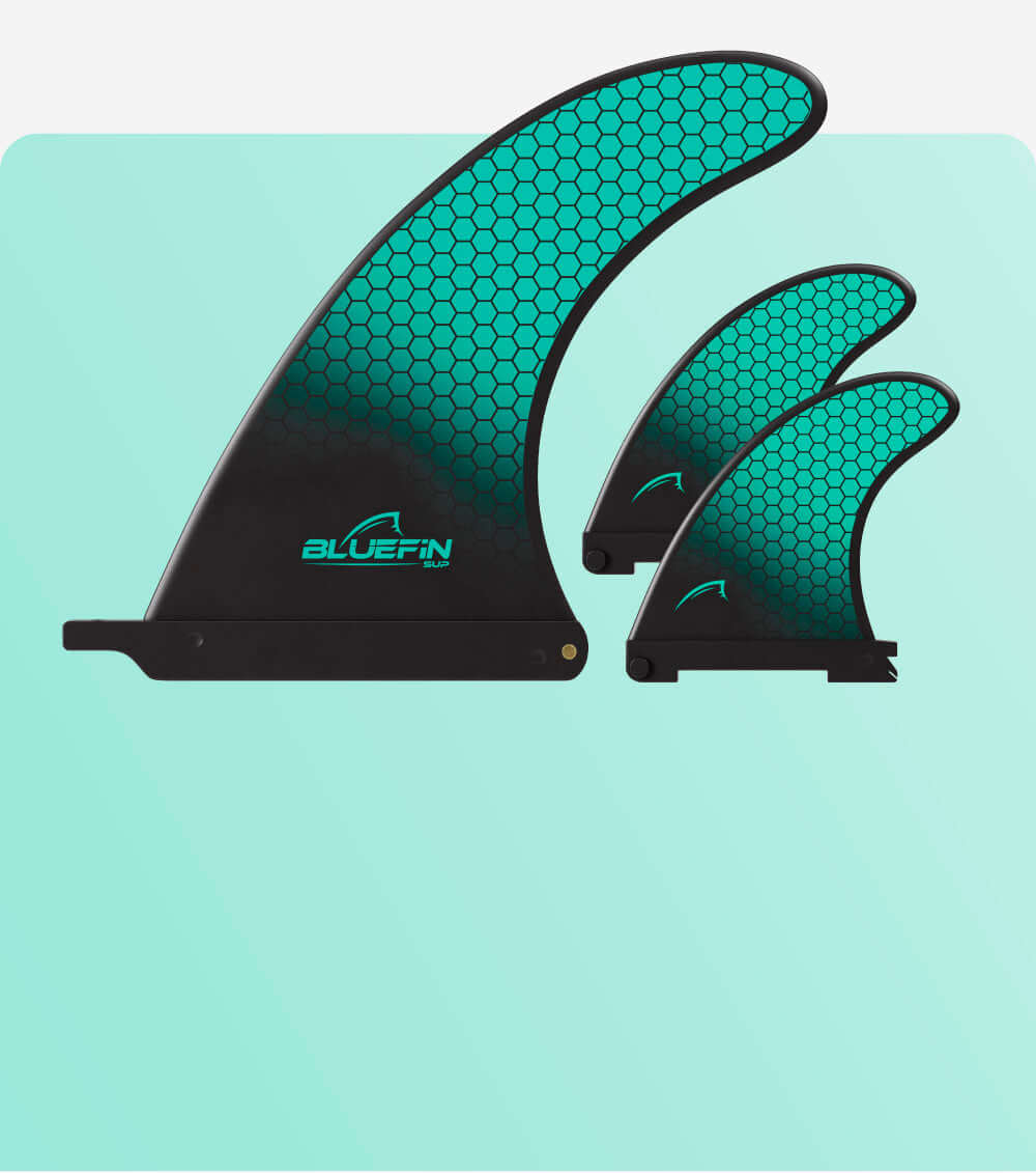 Trois ailerons SUP Bluefin de tailles variées avec un motif en nid d'abeille turquoise sur fond clair.