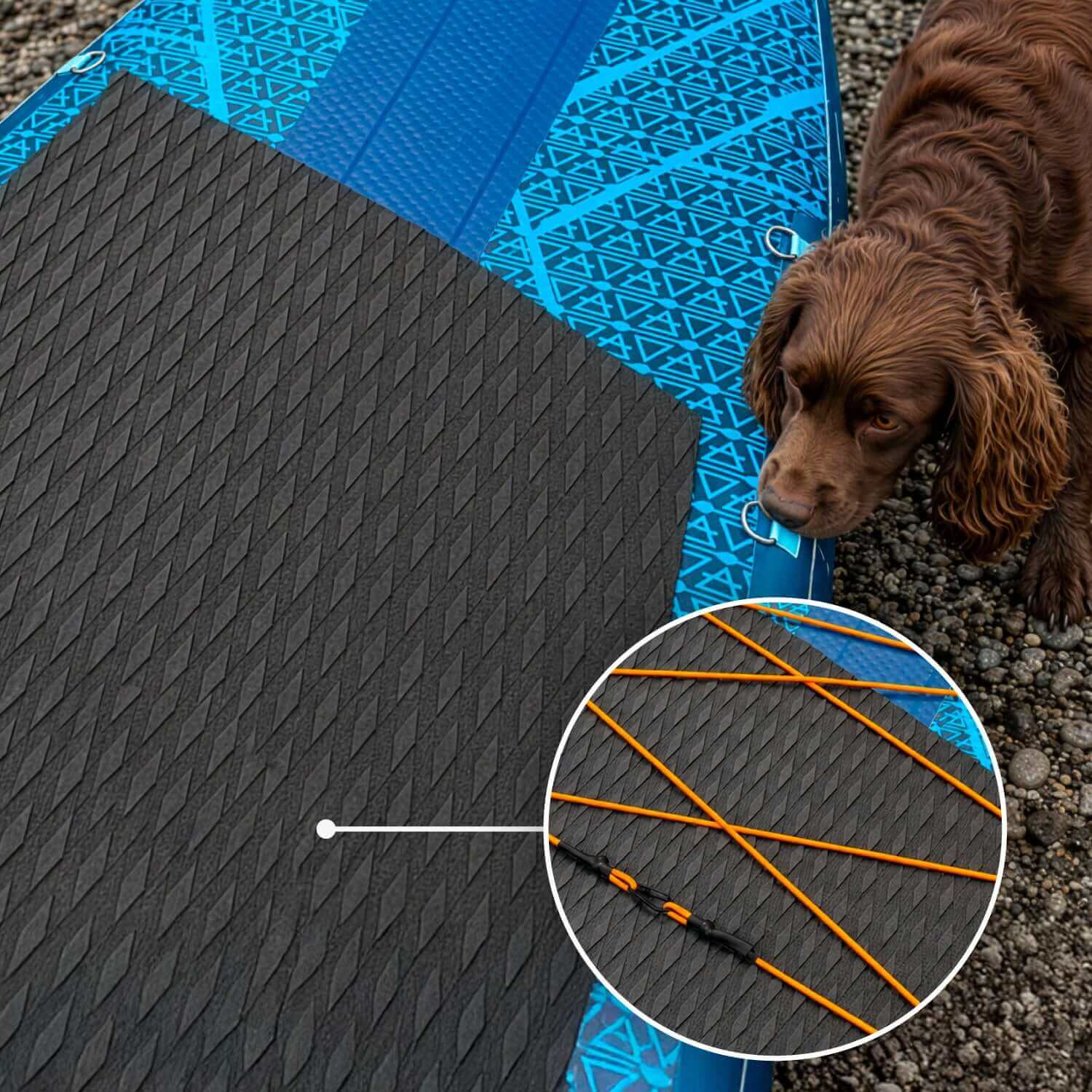 Inflatable paddleboard with textured black deck pad, orange bungee cords, and a brown dog nearby