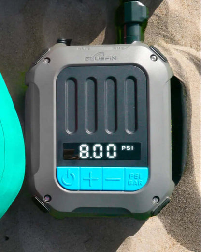 Digitaler Druckmesser zeigt 8,00 PSI an, mit Aufblas- und Ablassknöpfen, auf sandiger Oberfläche.