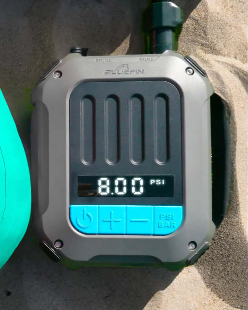 Digitaler Druckmesser zeigt 8,00 PSI an, mit Aufblas- und Ablassknöpfen, auf sandiger Oberfläche.