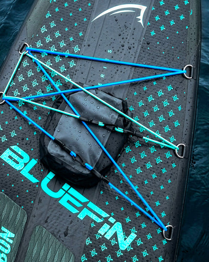 Inflatable paddleboard with blue bungee cords, textured surface, and a waterproof storage bag